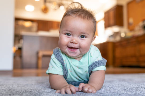 Baby laying on carpet floorings | Shoreline Flooring