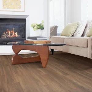 Laminate in a medium brown wood tone in a living room with a fireplace | Shoreline Flooring